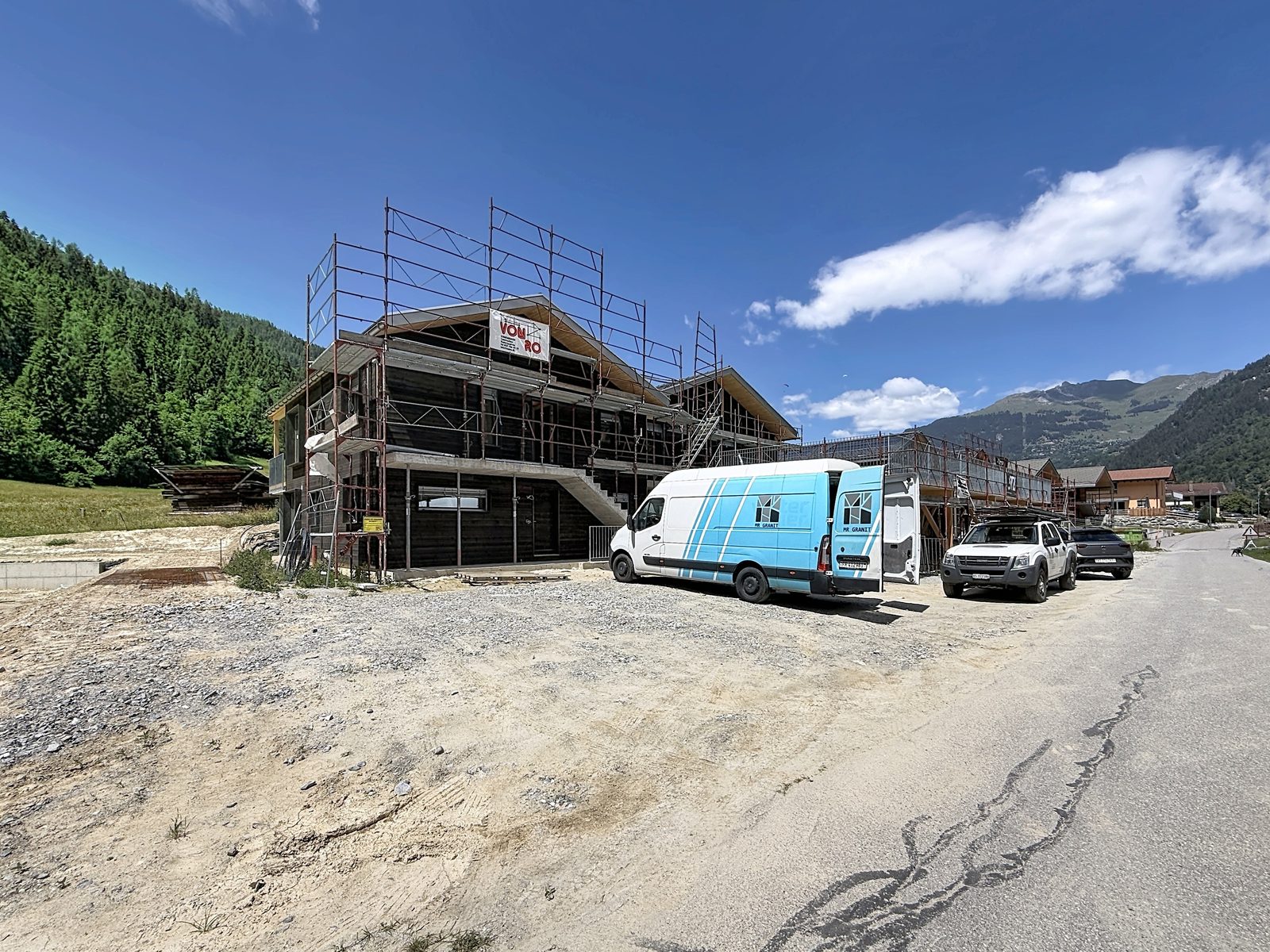 Le bâtiment de la Résidence Aureus en construction, échafaudage, face aux montagnes